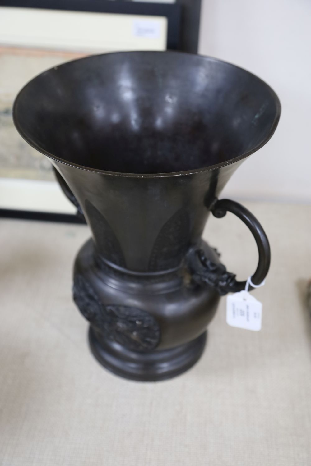 A large 19th century Japanese bronze two handled vase, cast with mythical beasts, 34cm high